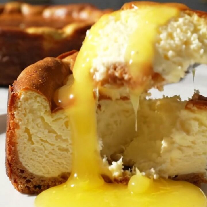 A close-up shot of a slice of Meyer lemon Basque cheesecake with a molten center and a burnt top.