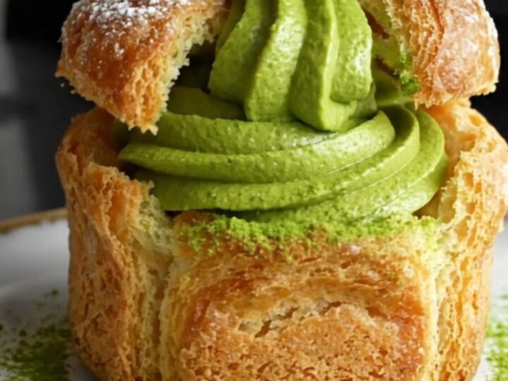 A towering matcha cruffin showing flaky spiral layers and a rich green matcha ganache filling.
