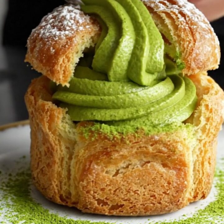 A towering matcha cruffin showing flaky spiral layers and a rich green matcha ganache filling.