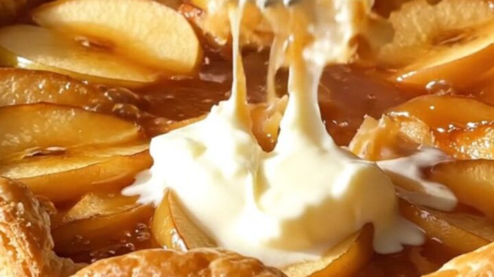 A golden, caramelized Apple Tarte Tatin served on a rustic platter.