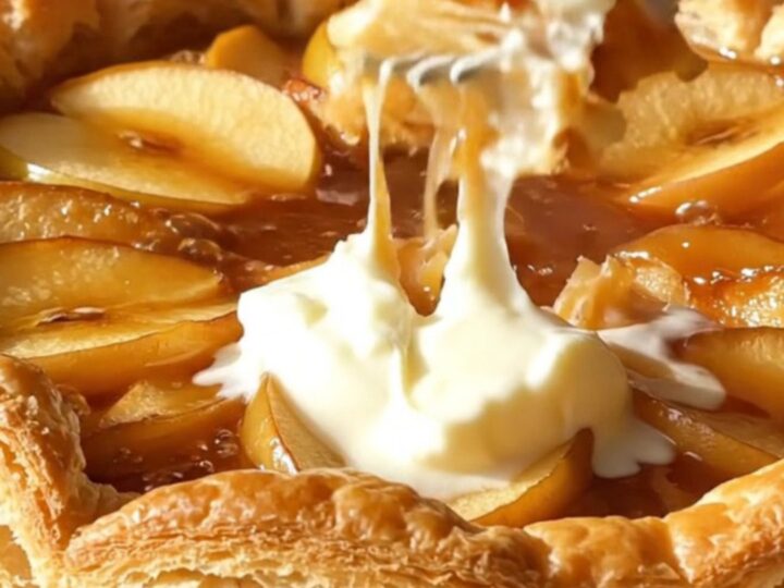 A golden, caramelized Apple Tarte Tatin served on a rustic platter.