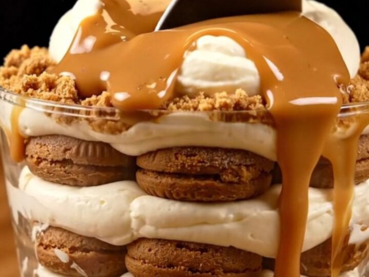 A close-up of a creamy Lotus Biscoff tiramisu in a square dish with a spoonful being taken out.
