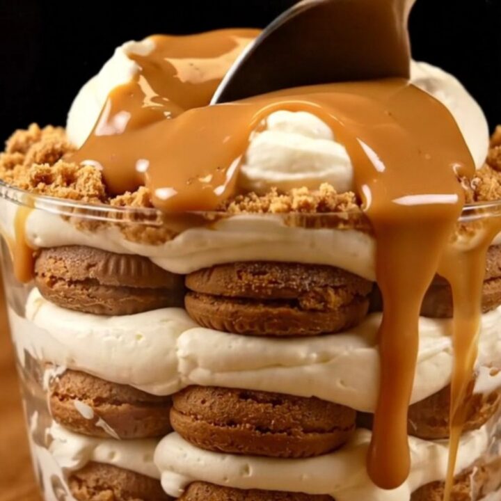 A close-up of a creamy Lotus Biscoff tiramisu in a square dish with a spoonful being taken out.