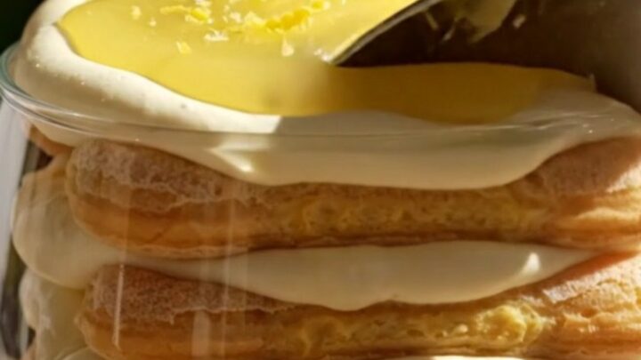 A close-up of a spoonful of creamy Lemon Limoncello Tiramisu with glossy lemon curd swirls and candied lemon zest.