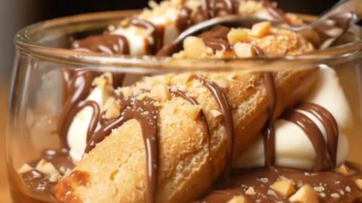 A close-up shot of a creamy Nutella tiramisu with hazelnut garnish in a glass dish.