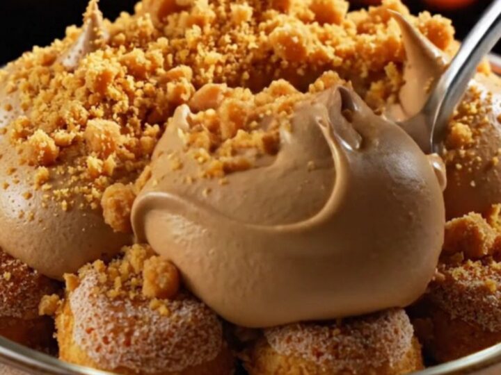 A close-up of a square of pumpkin spice chai latte tiramisu with piped mascarpone peaks and cookie crumbs.
