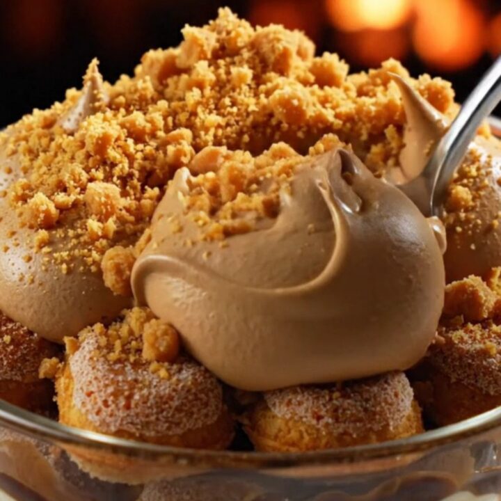 A close-up of a square of pumpkin spice chai latte tiramisu with piped mascarpone peaks and cookie crumbs.
