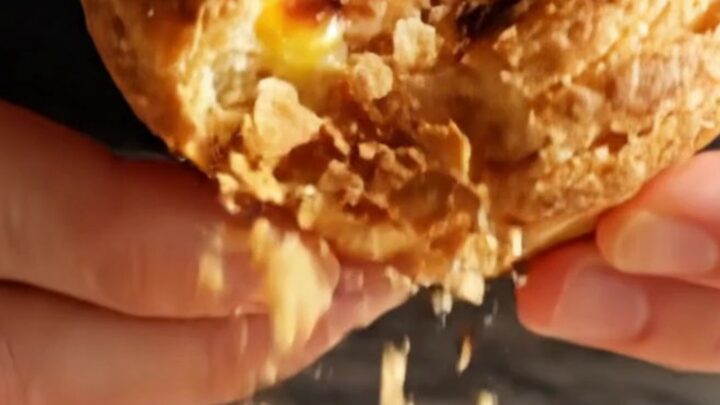 A close-up shot of a freshly baked Portuguese Pastel de Nata with a perfectly blistered, caramelized custard top.