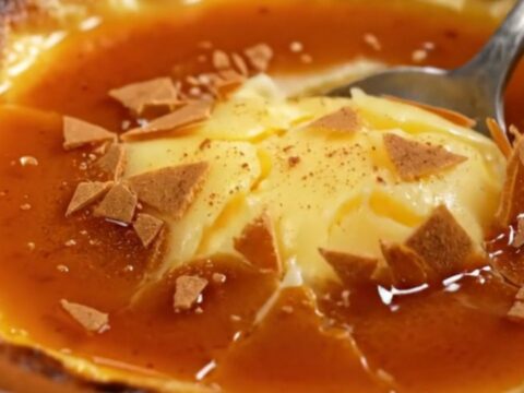 A close-up of a traditional Spanish Crema Catalana in a clay cazuela with a perfectly browned, burnt sugar crust.