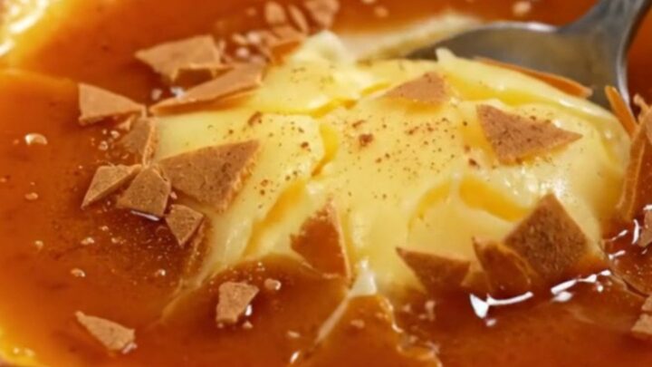 A close-up of a traditional Spanish Crema Catalana in a clay cazuela with a perfectly browned, burnt sugar crust.