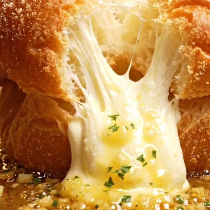 A close-up shot of a Korean garlic cream cheese brioche bun being pulled apart to reveal the creamy filling.