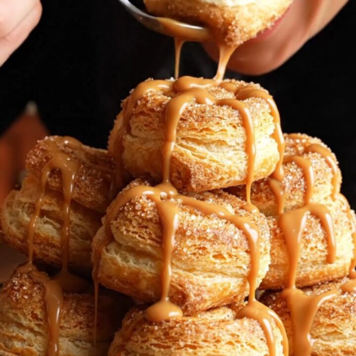 Close-up of golden, crispy churro cheesecake pinwheels with a visible creamy vanilla center.