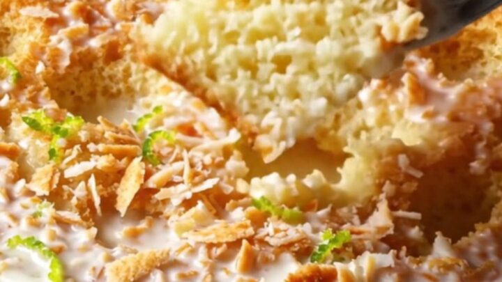 A slice of tropical Coconut Tres Leches cake topped with toasted coconut and lime zest on a plate.