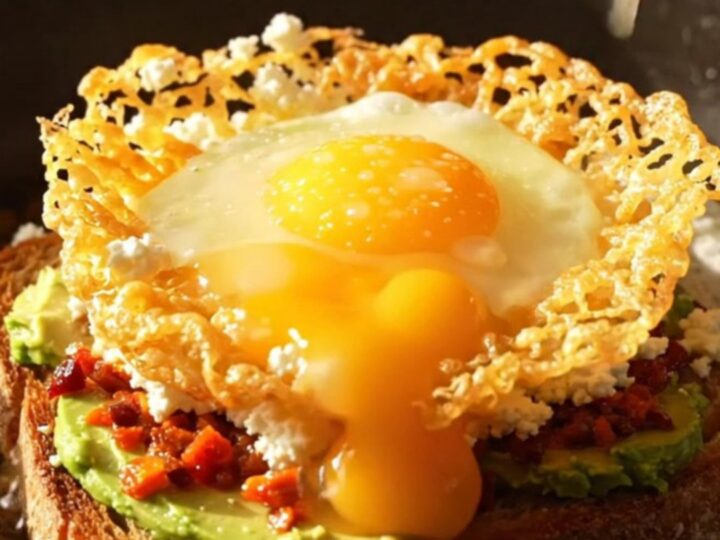 A close-up of a crispy golden feta ring surrounding a runny egg on a slice of sourdough bread.