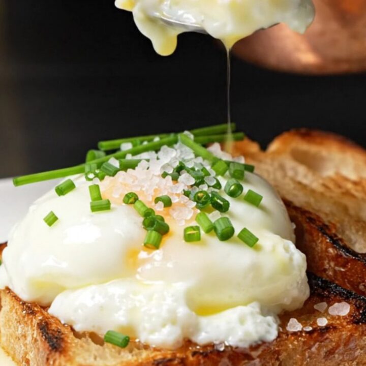 Glossy, soft-curd scrambled eggs served on a piece of charred brioche toast, garnished with chives.