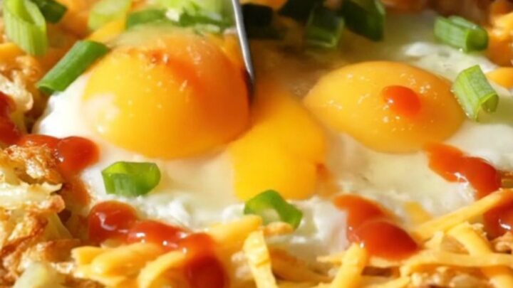 A golden-brown shredded potato nest in a cast-iron skillet, filled with two perfectly baked eggs and melted sharp cheddar.