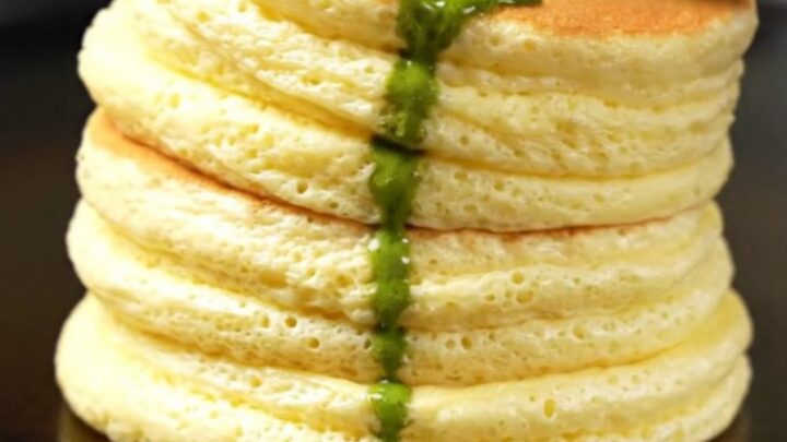 Two tall, jiggly Japanese cloud pancakes stacked on a plate with melting matcha butter.