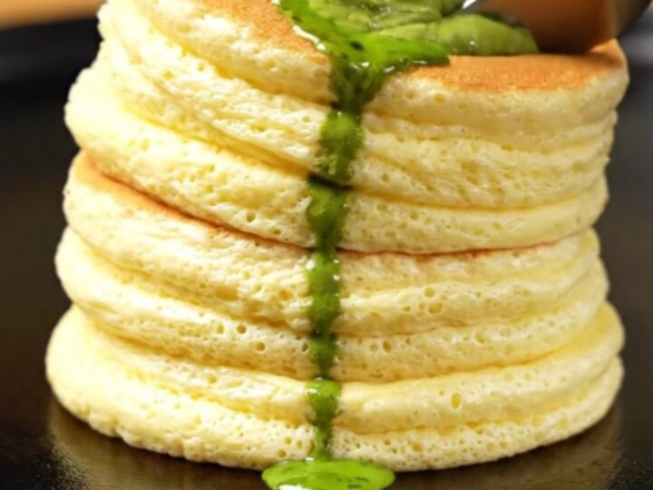 Two tall, jiggly Japanese cloud pancakes stacked on a plate with melting matcha butter.