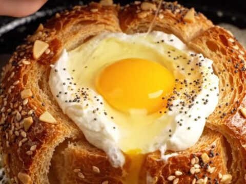 A close-up of a crispy golden brioche slice with a perfectly runny egg yolk in the center