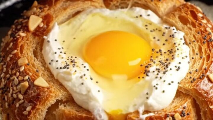 A close-up of a crispy golden brioche slice with a perfectly runny egg yolk in the center