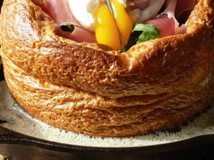A savory Dutch baby in a cast-iron skillet, topped with prosciutto, arugula, and a poached egg.