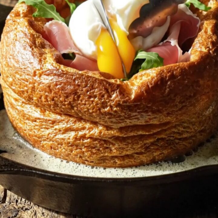 A savory Dutch baby in a cast-iron skillet, topped with prosciutto, arugula, and a poached egg.