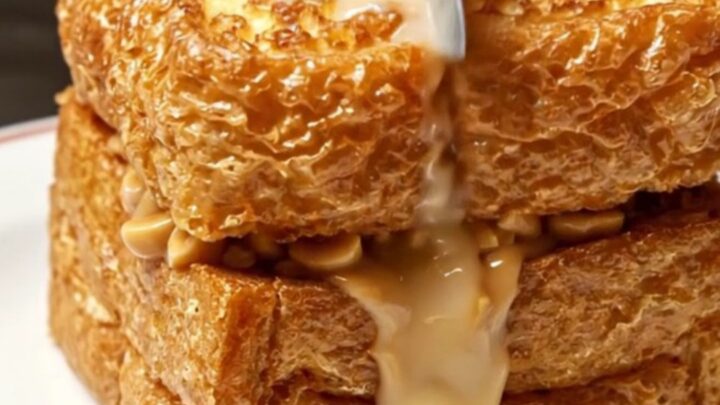 A golden-brown crispy Hong Kong style peanut butter French toast topped with a melting pat of butter and condensed milk.