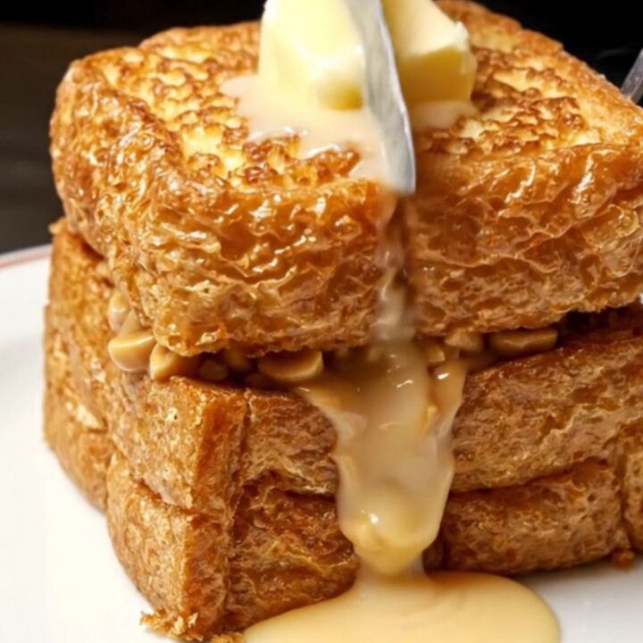A golden-brown crispy Hong Kong style peanut butter French toast topped with a melting pat of butter and condensed milk.