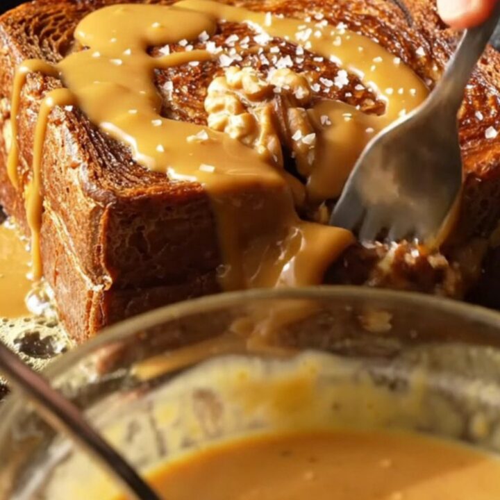 A golden-brown slice of walnut banana bread French toast topped with glossy tahini caramel and sea salt.