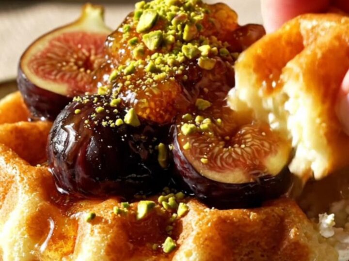 Close up of golden almond ricotta waffles topped with jammy black mission figs and honey.
