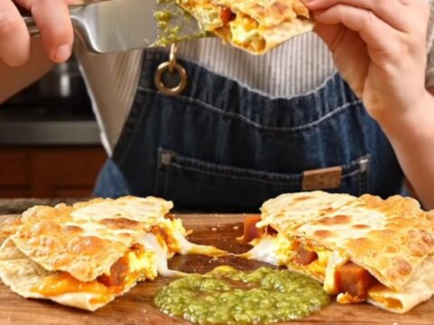 A crispy, golden-brown Parmesan-crusted quesadilla being pulled apart to reveal a gooey, cheesy interior.
