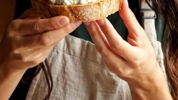 Close-up of a toasted sourdough slice topped with whipped ricotta, roasted figs, and prosciutto.