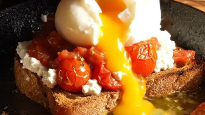 Vibrant whipped feta sourdough toast topped with blistered za'atar cherry tomatoes and a poached egg.
