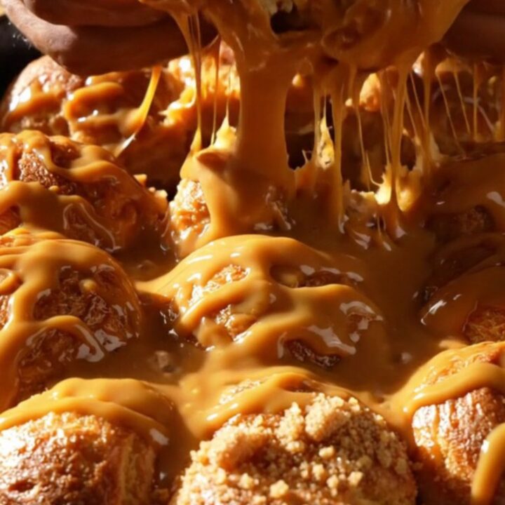 A steaming pull-apart brioche monkey bread in a cast-iron skillet with glossy butterscotch glaze.