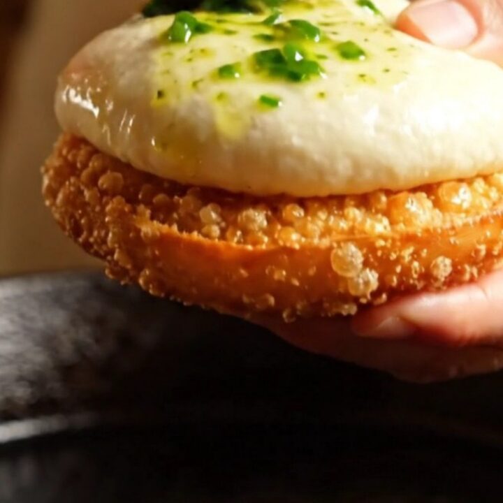 Golden pan-seared chicken and shiitake baozi torn open showing steaming savory filling and crispy base.