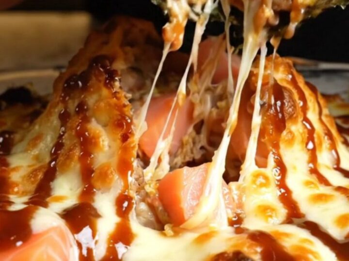 A vibrant volcano salmon sushi bake in a baking dish with golden, bubbling cheese peaks and colorful garnishes.