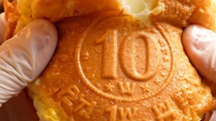 A golden, coin-shaped pancake split in half showing a long, stretchy pull of melted mozzarella cheese.