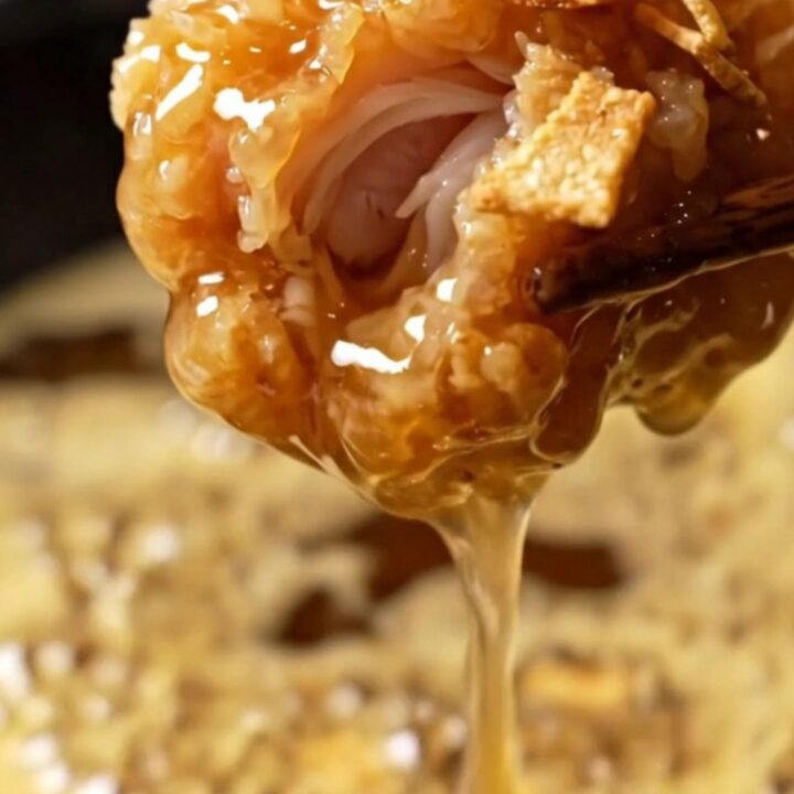 Close up shot of crispy golden honey butter garlic chicken tenders glistening under warm lighting.