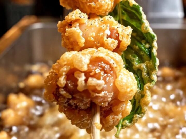 Golden, crispy Taiwanese popcorn chicken nuggets in a bowl with fried Thai basil leaves.