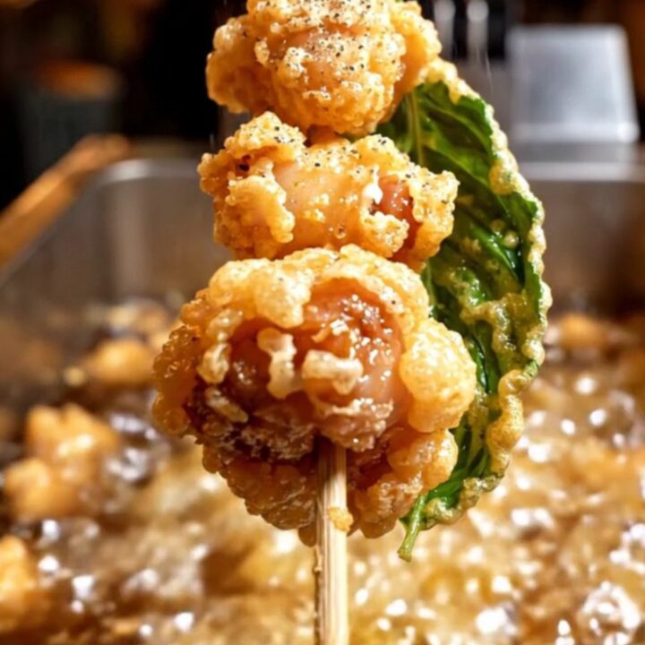 Golden, crispy Taiwanese popcorn chicken nuggets in a bowl with fried Thai basil leaves.