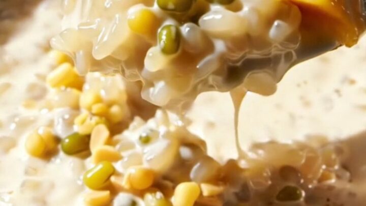 Close up of creamy Thai mango sticky rice topped with crunchy mung beans on a plate.