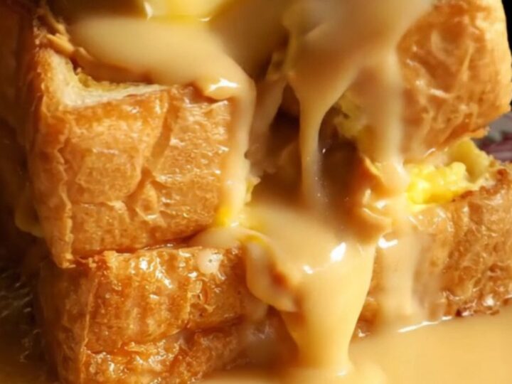 A close-up shot of golden-brown Hong Kong French toast with peanut butter oozing from the center.