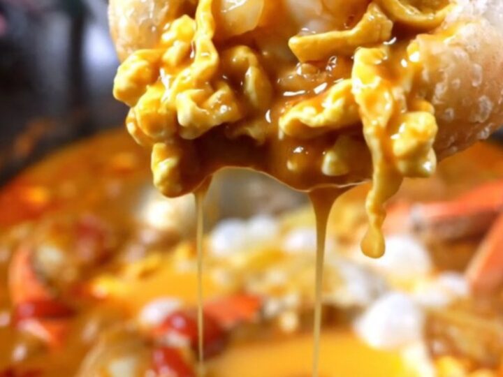 Golden fried mantou buns served alongside a bowl of rich, red Singapore chili crab gravy with visible egg ribbons.