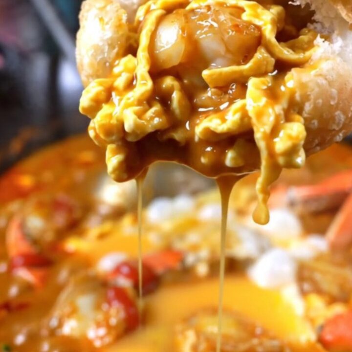 Golden fried mantou buns served alongside a bowl of rich, red Singapore chili crab gravy with visible egg ribbons.