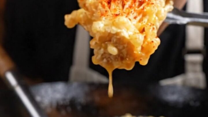 A golden, crispy cluster of fried enoki mushrooms dusted with vibrant red Sichuan mala spices.