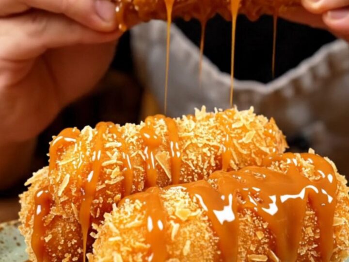 A close-up of a golden-brown banana turon split in half, showing the steaming banana and jackfruit filling with a crackling