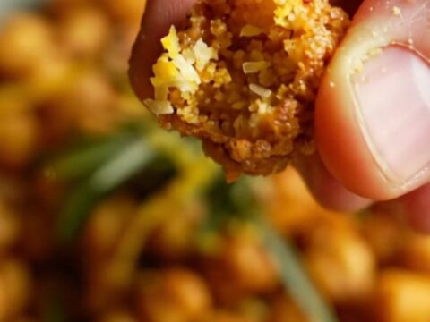 A ceramic bowl filled with golden, blistered air-fryer chickpeas seasoned with paprika and herbs.