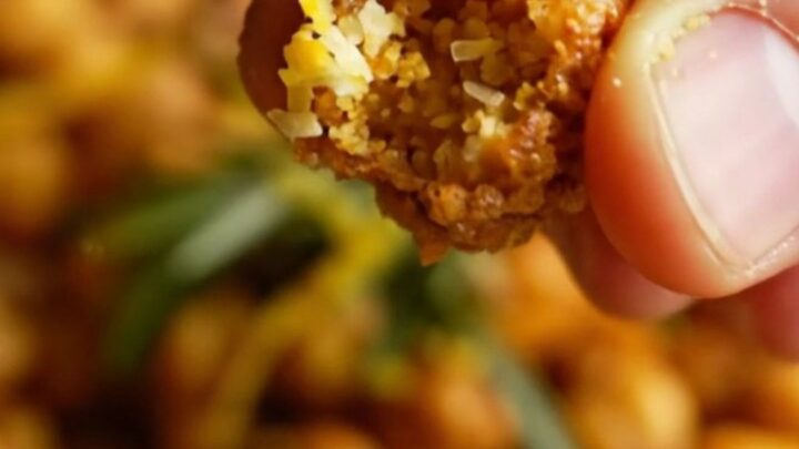A ceramic bowl filled with golden, blistered air-fryer chickpeas seasoned with paprika and herbs.