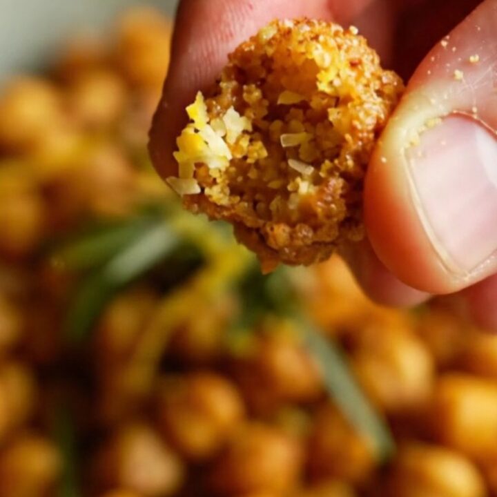 A ceramic bowl filled with golden, blistered air-fryer chickpeas seasoned with paprika and herbs.
