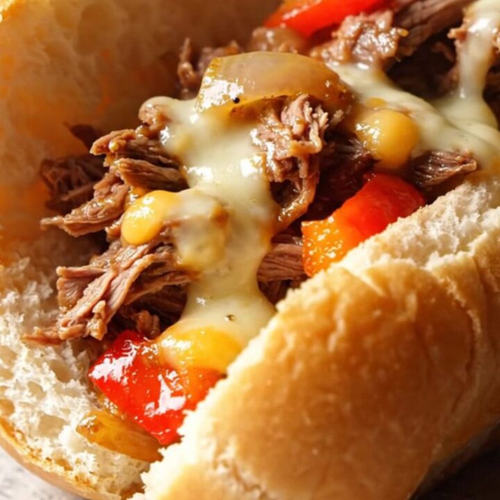 A delicious Philly cheesesteak sandwich filled with shredded ribeye, peppers, and melted cheese.